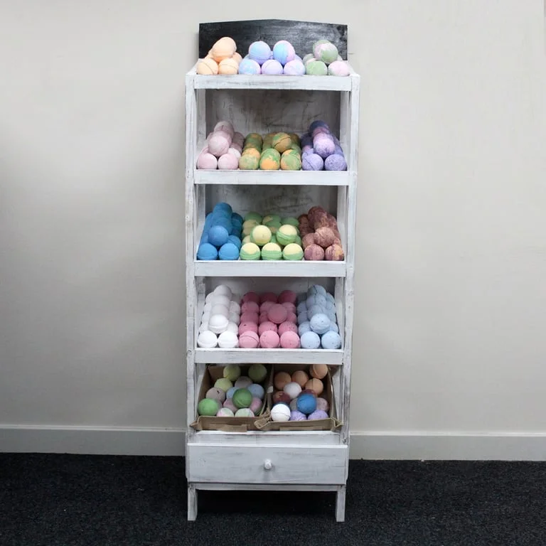 Five whitewash bath bombs displayed on a clear bath bomb shelf