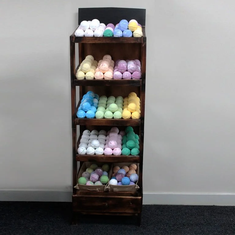 Bath bomb display shelf showing five pill‑shaped Brownwash bath bombs arranged on a wooden shelf