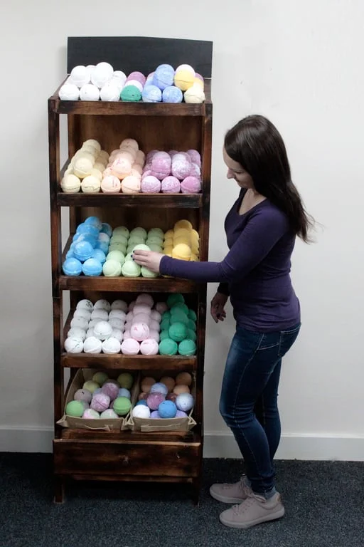 Brownwash bath bomb holder with five shelves displayed on a countertop, holding bath bombs.