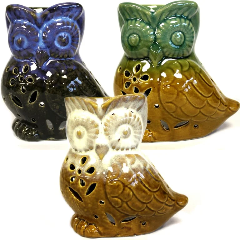 Side‑on view of a rustic owl oil burner on a wooden base, showing its classic enamel finish and owl details.