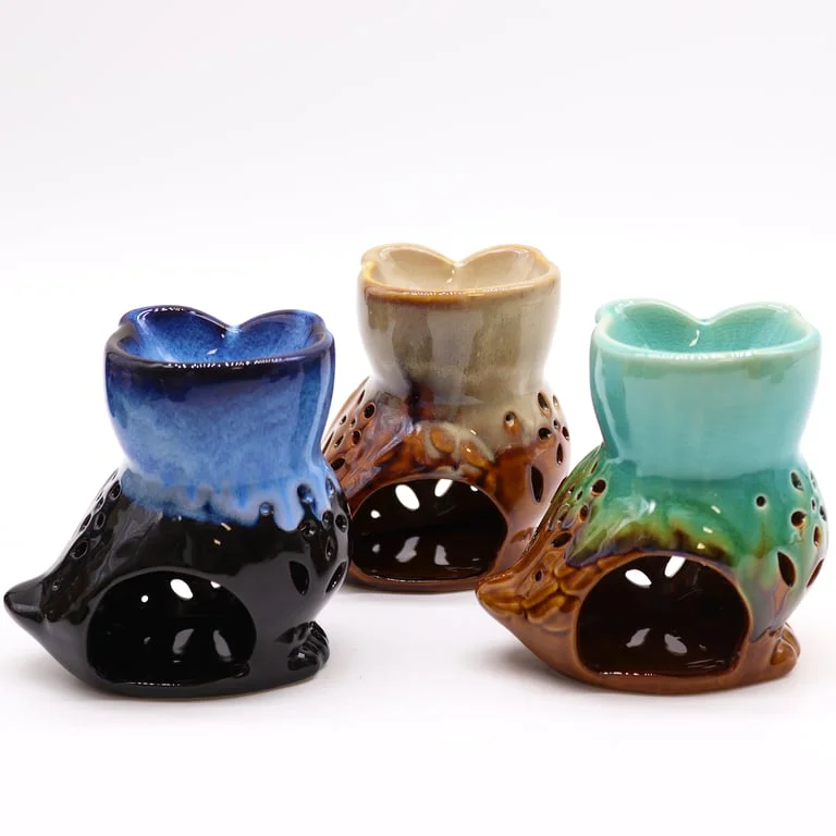 Rustic owl oil burner shown side‑on, metal body with feather detail, ornate rustic finish