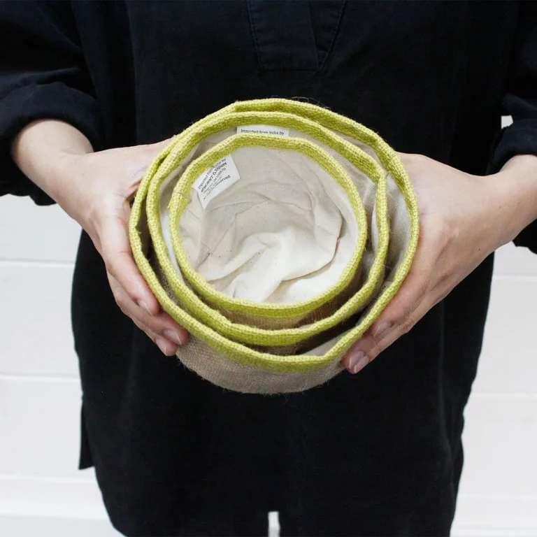 Set of 3 charcoal natural jute baskets on a flat surface.