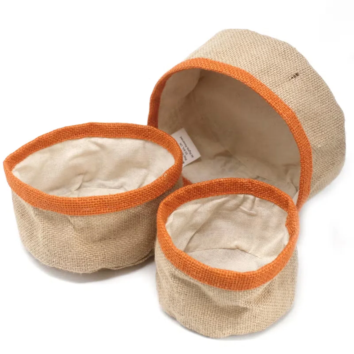 Three turmeric-coloured natural jute storage baskets natural, stacked with varying sizes on a white background