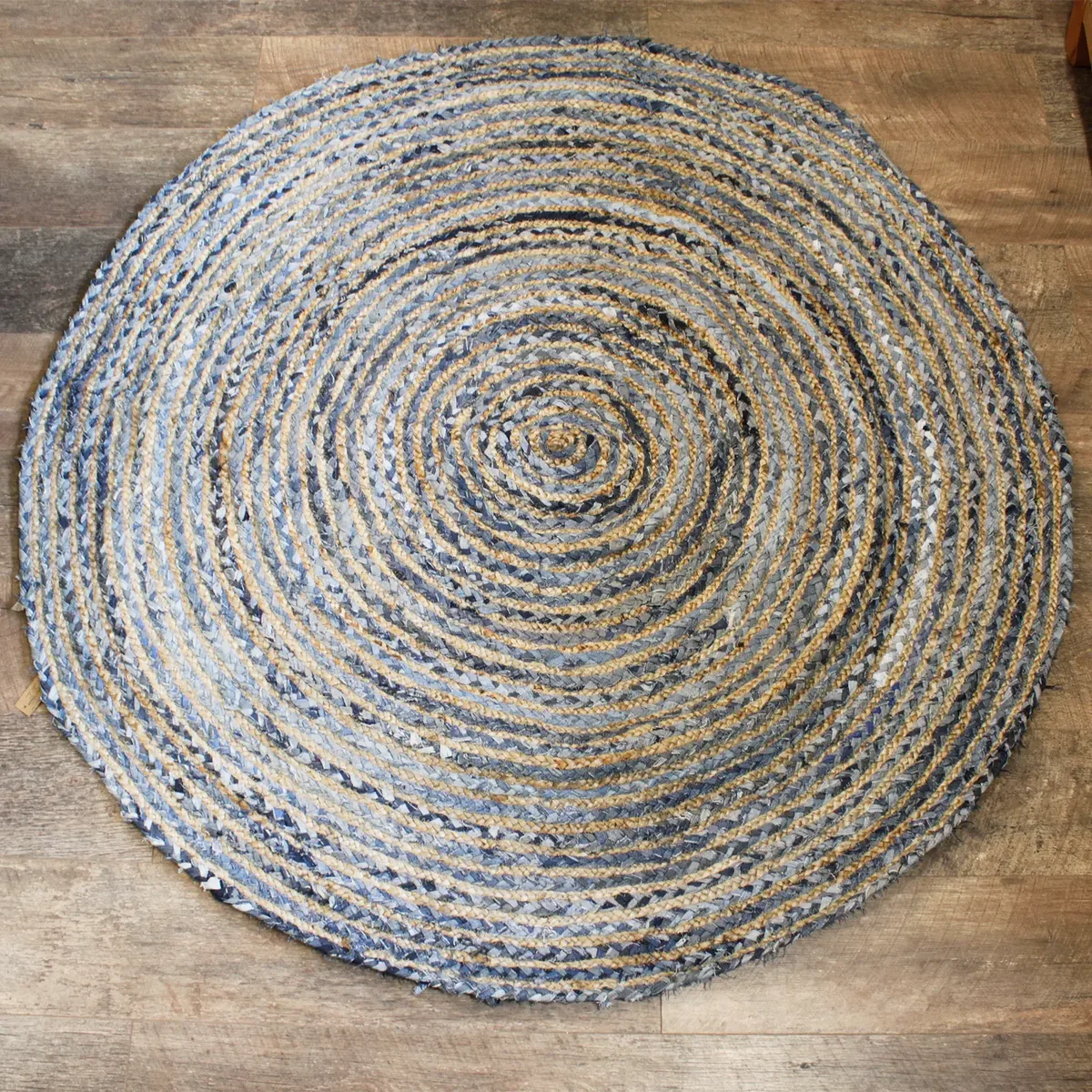 Round 150 cm rug made of jute and recycled denim, featuring a textured weave and earthy tones.