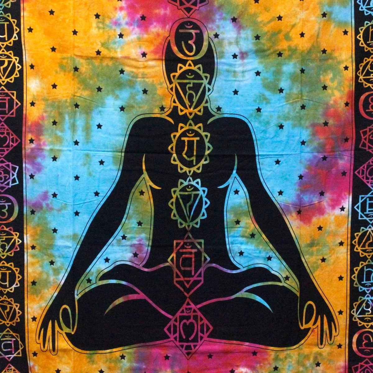 Buddha bedspread and matching wall hanging in vibrant chakra colors on a folded cotton sheet