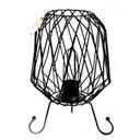 Mesh iron lamp with exposed steel mesh base, attached cable, and a modern bulb on a base, styled for industrial décor.