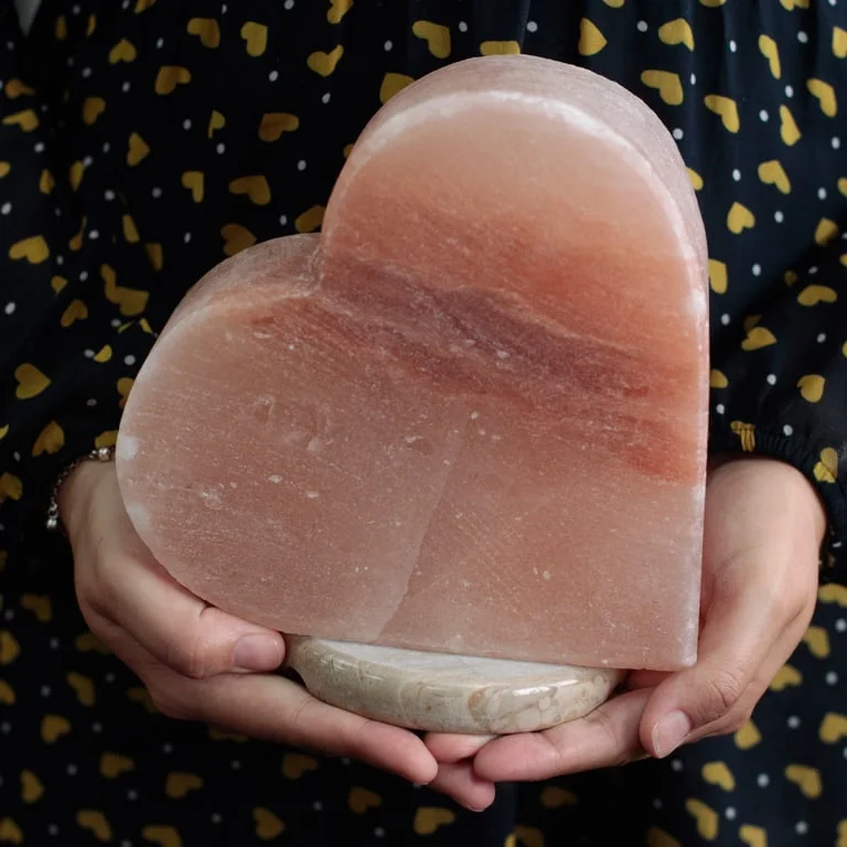 Heart salt lamp made from natural salt crystal, softly glowing in a heart shape.