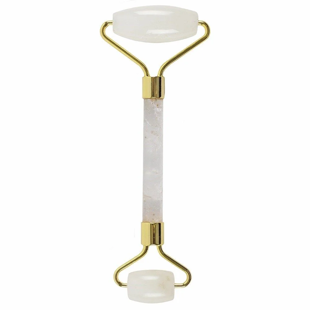 Gemstone face roller made of clear rock quartz with smooth rolling stones on a handle against a white background