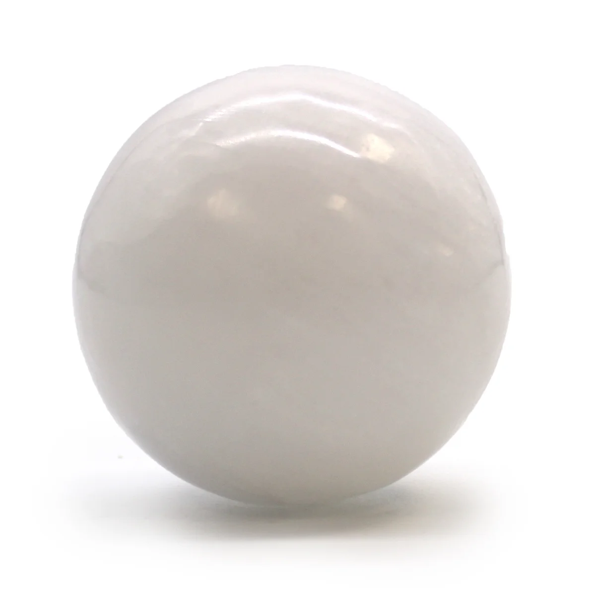 Smooth translucent 5-6 cm crystal sphere made of selenite on a plain white background