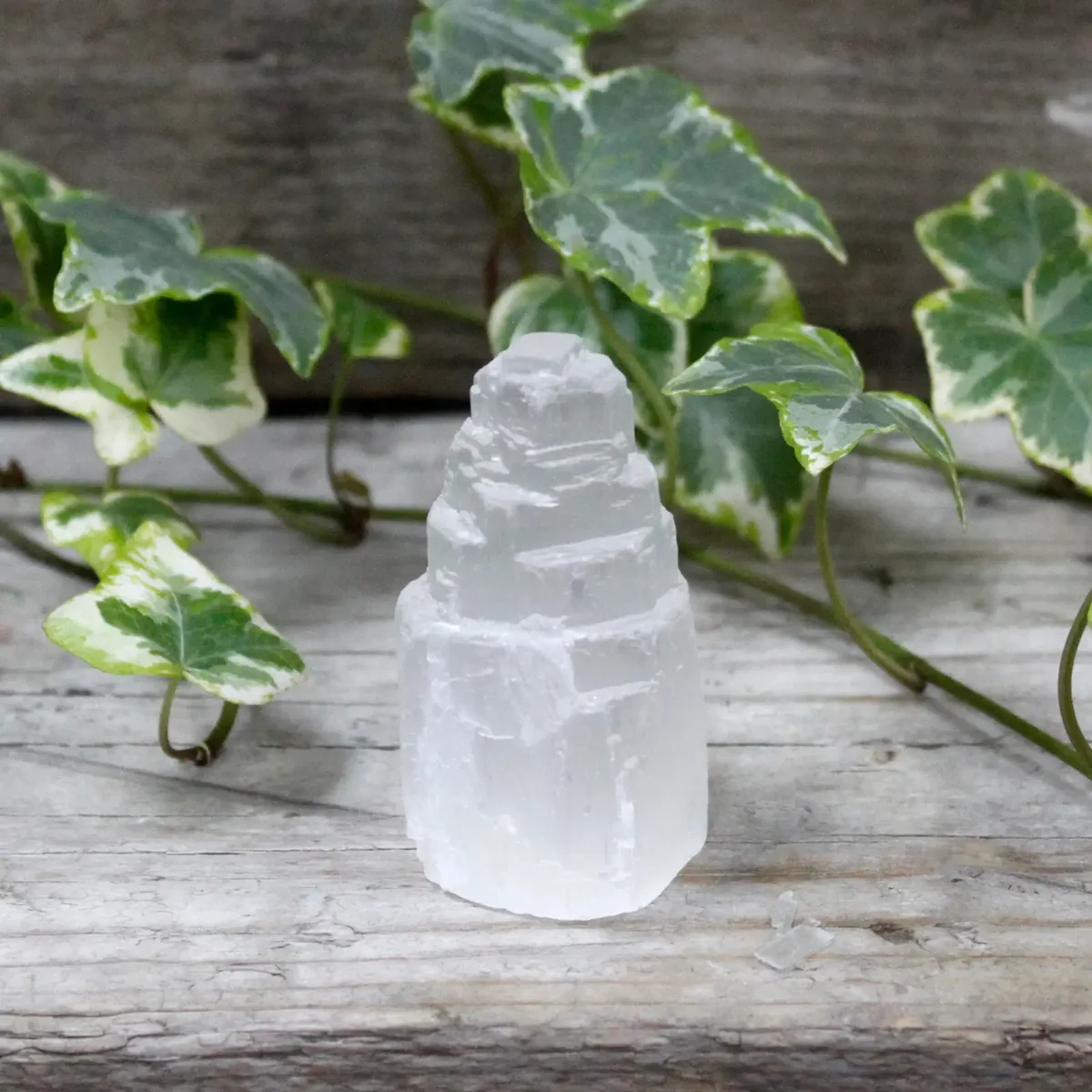 Selenite crystal tower, 5 cm tall, natural translucent white crystal, slender tower shape.