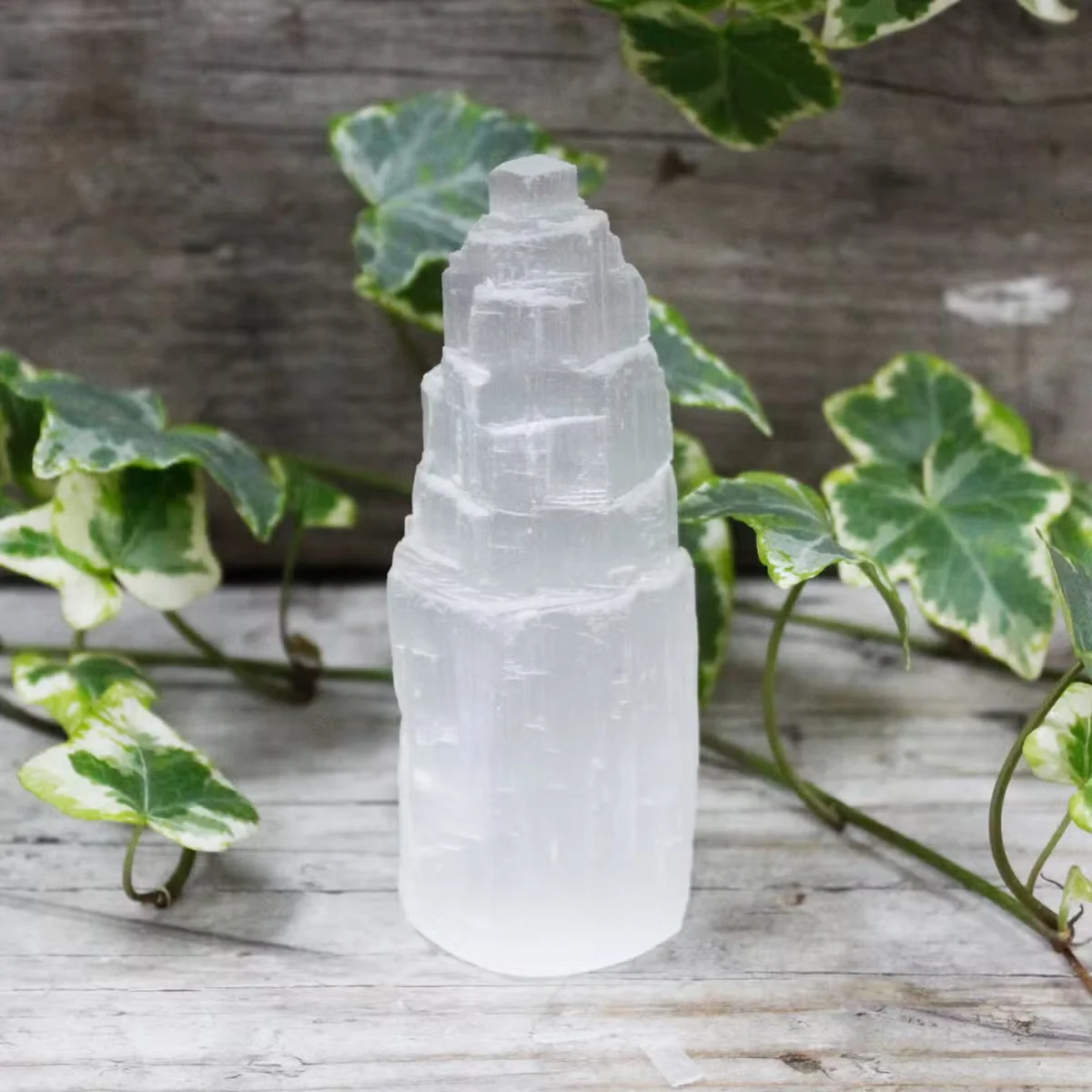 Clear selenite tower 10 cm on white background, natural crystal decor
