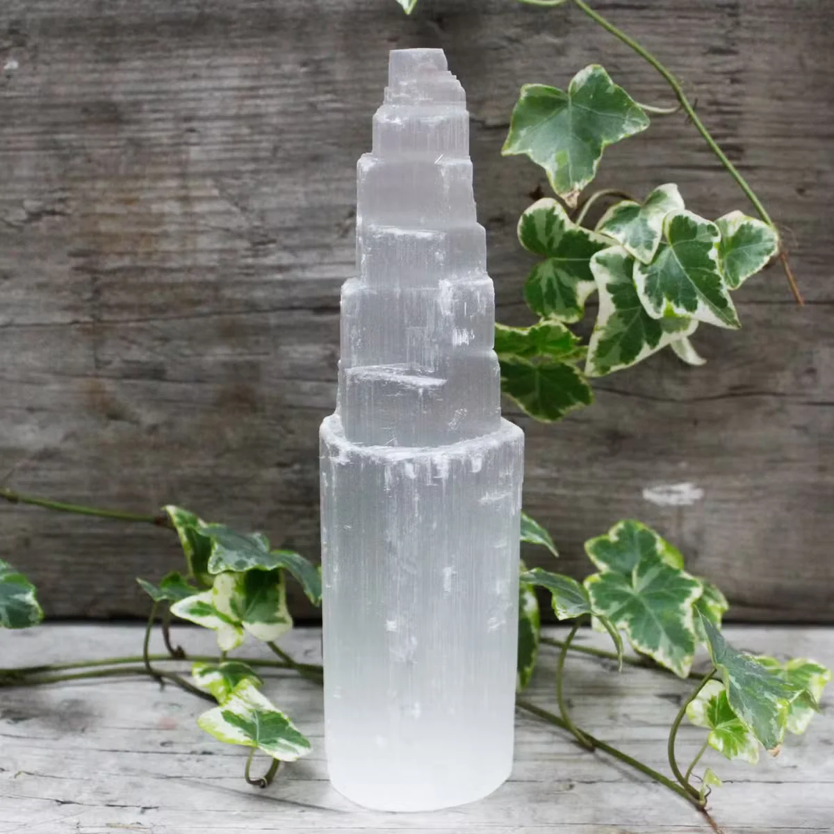 Decorative selenite tower, 20 cm tall, translucent crystal tower on neutral background