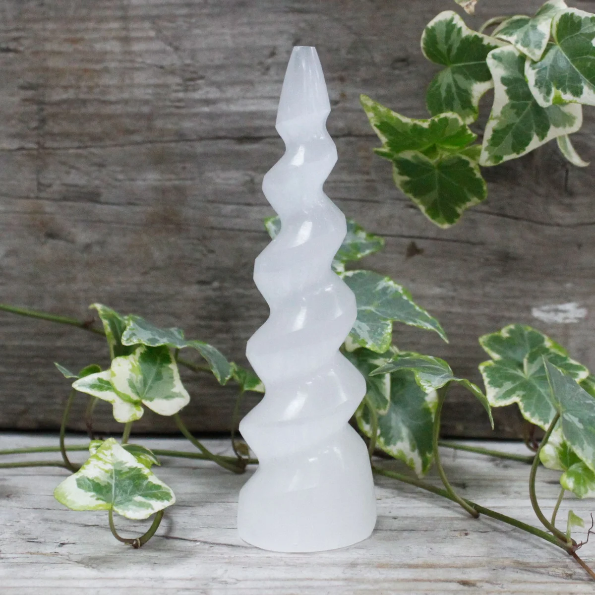 Selenite unicorn horn tower standing at 15 cm height with spiral design in a light crystal.