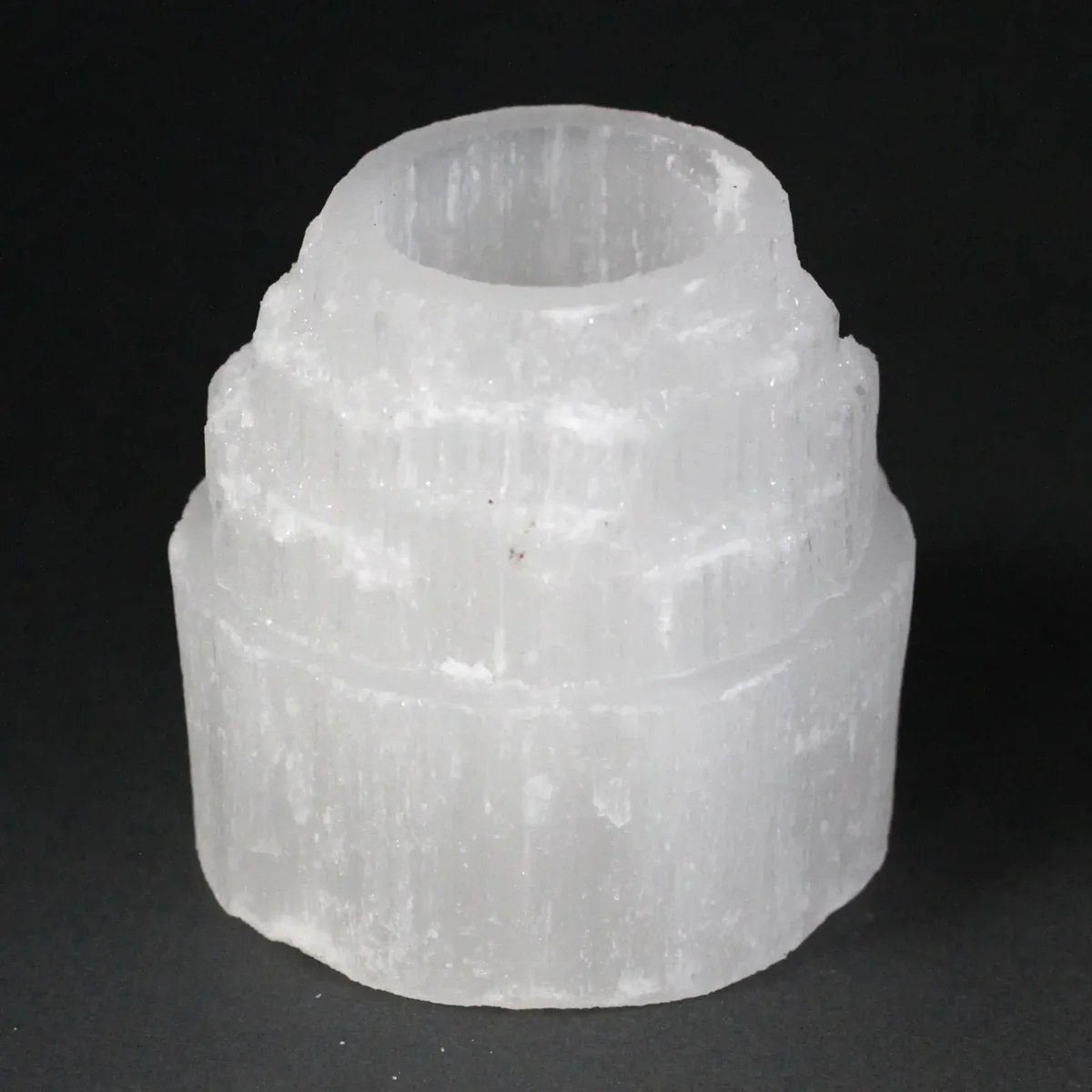 Selenite mountain top candle holder standing upright, 8 cm tall, clear translucent stone base.
