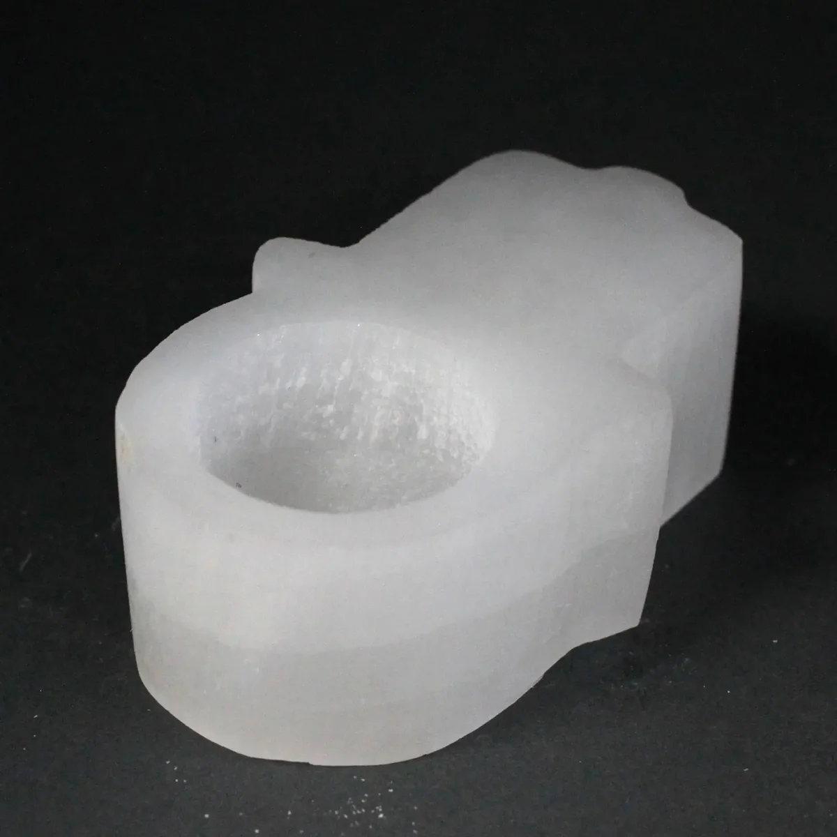 Selenite Hamsa candle holder, translucent hand shape with carved palm ready for a candle.