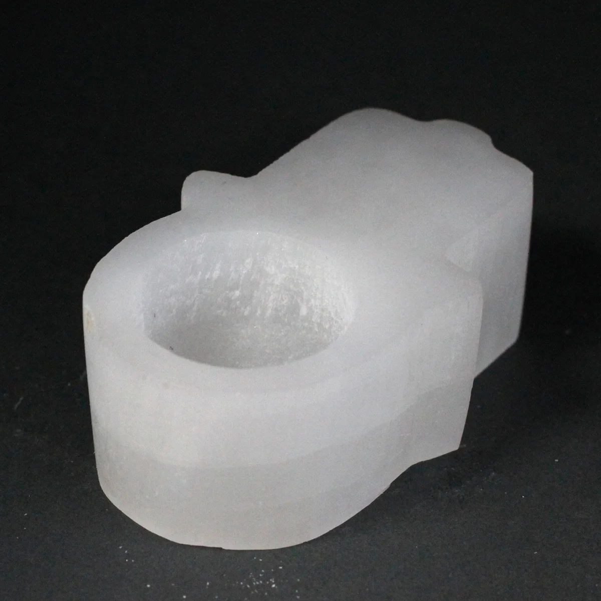 Decorative candle holder made of selenite, showcasing a Hamsa palm design.