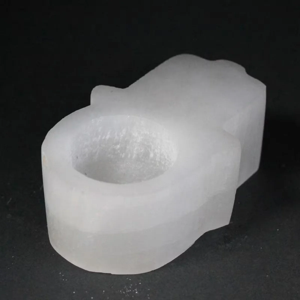 Natural selenite decor featuring a hand-shaped hamsa candle holder
