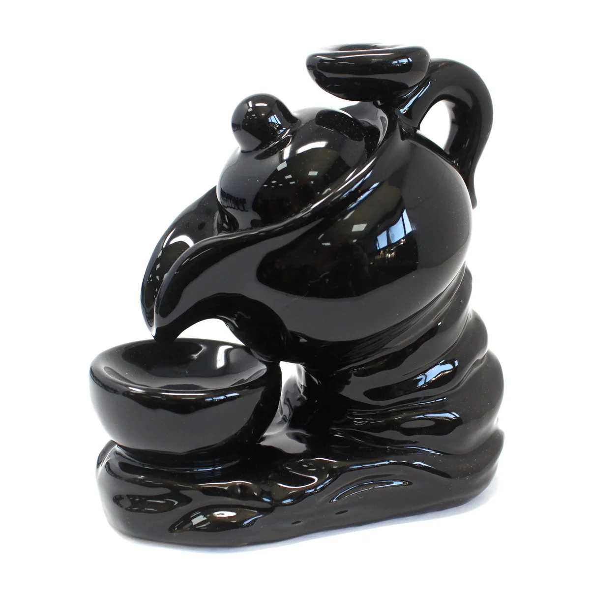 Ceramic tea pot shaped backflow incense burner with smoke flowing downwards for calming ambiance