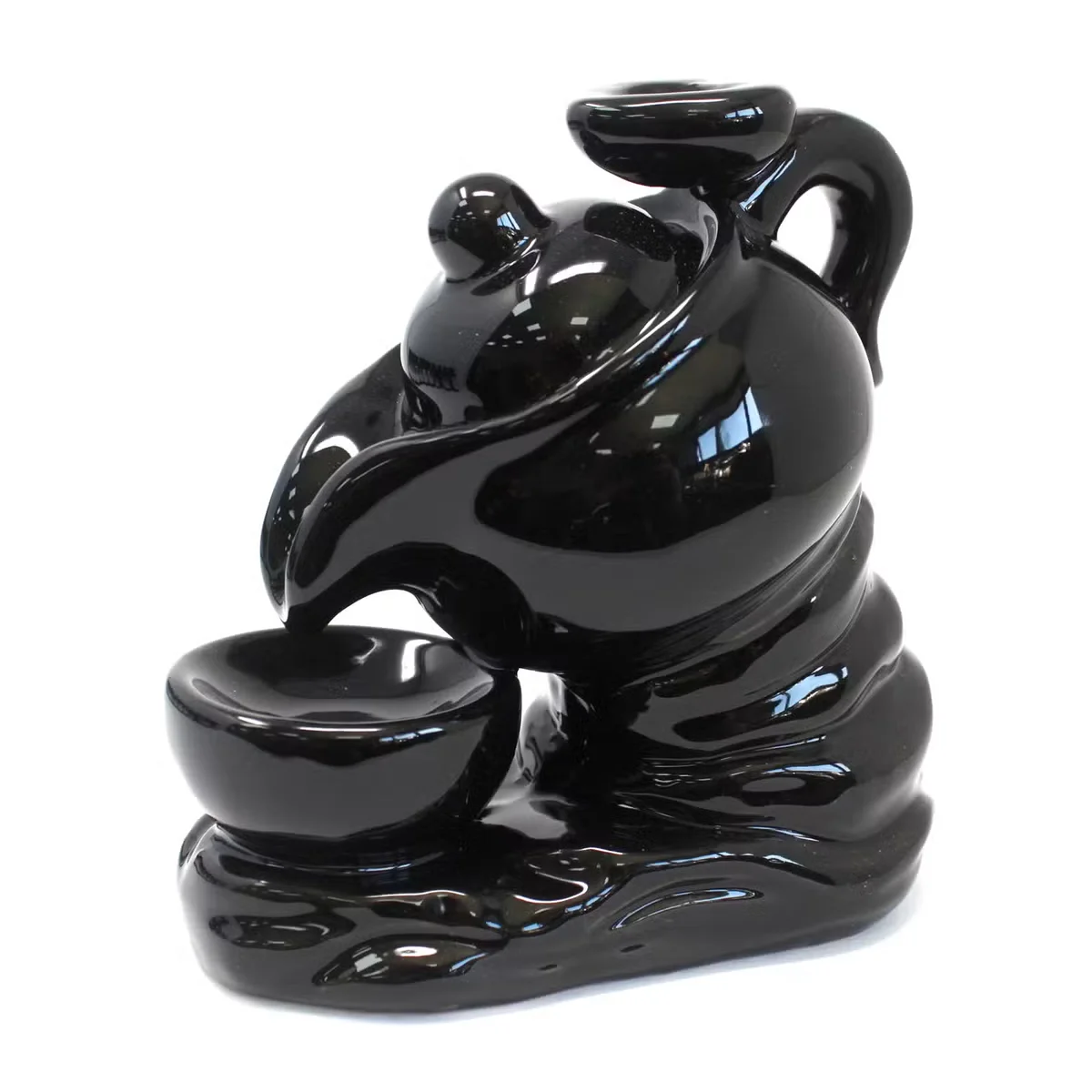 Ceramic tea pot backflow incense burner with smoke cascading down, designed as a smoke waterfall burner for relaxation
