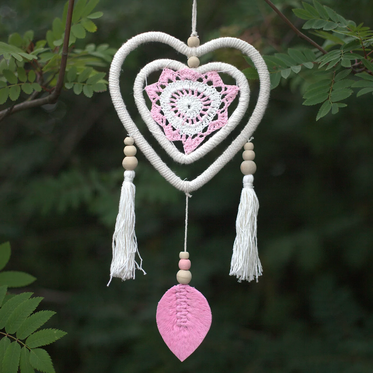 Medium pink dream catcher featuring heart in heart decor with intricate web and hanging feathers