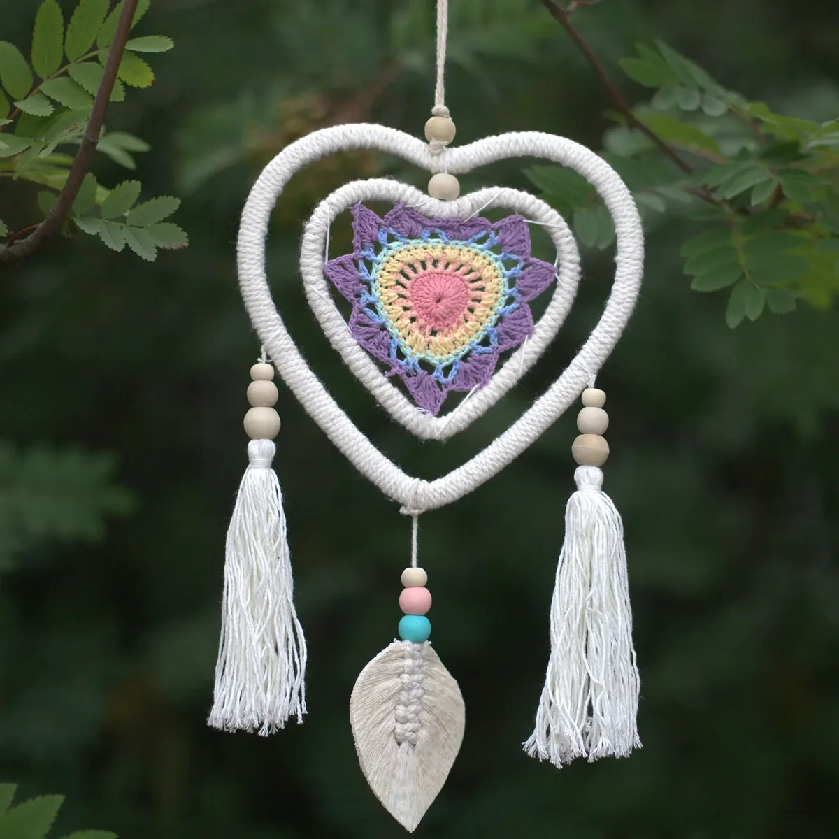 Medium heart in heart dream catcher with multiple layered hearts in soft colors hanging on a white background