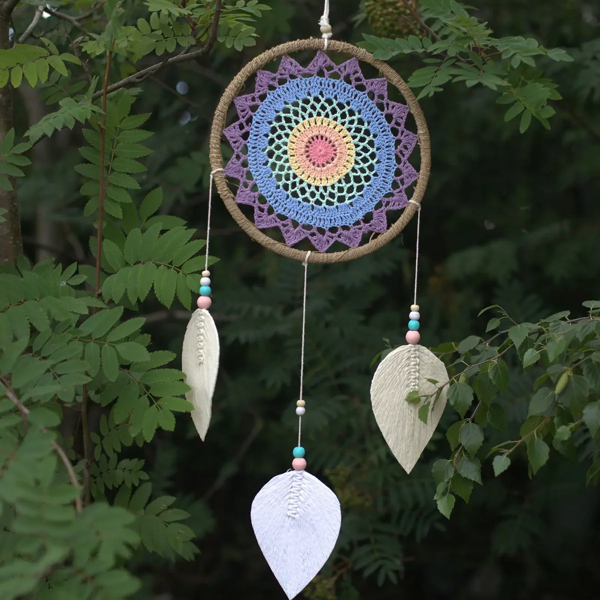 Large multi elemental spirits dream catcher with intricate web and decorative feathers hanging on wall background