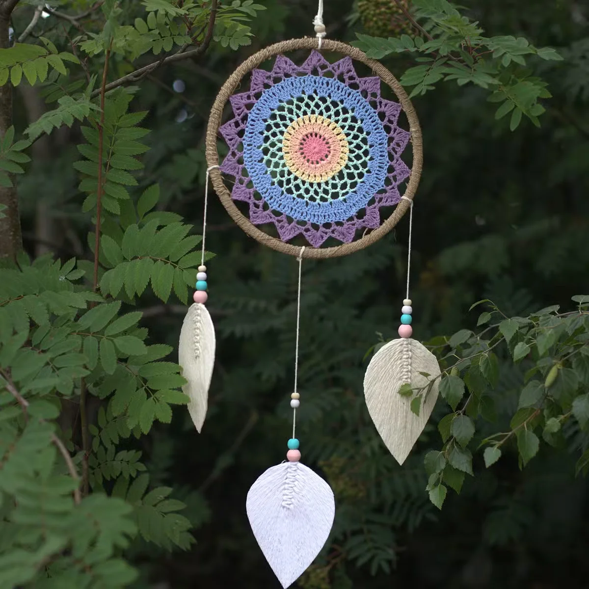 Large bohemian style dream catcher featuring multi elemental spirits design with intricate web and hanging feathers