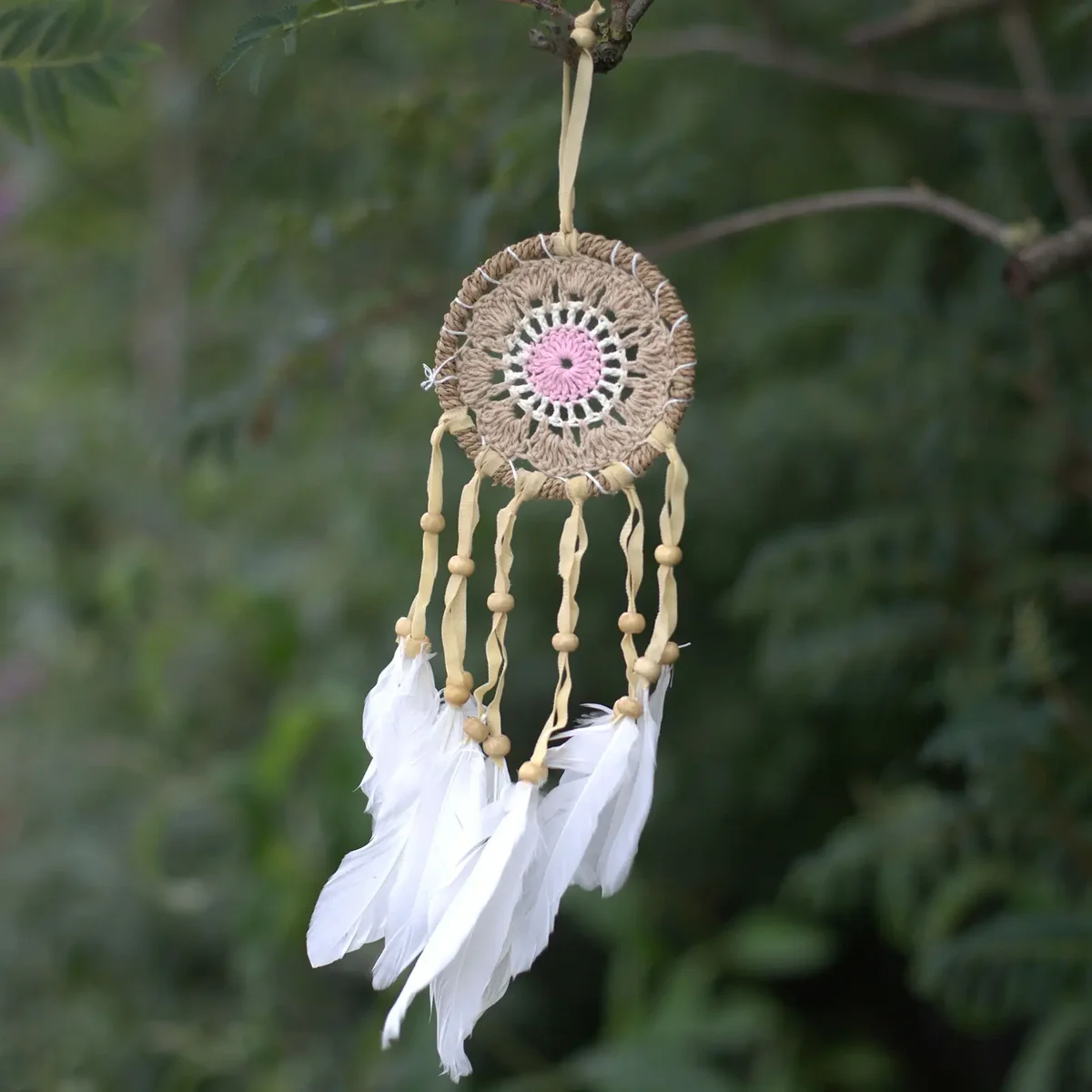 Pastel pink 9cm macramé dream catcher with intricate woven design and hanging tassels in assorted colours
