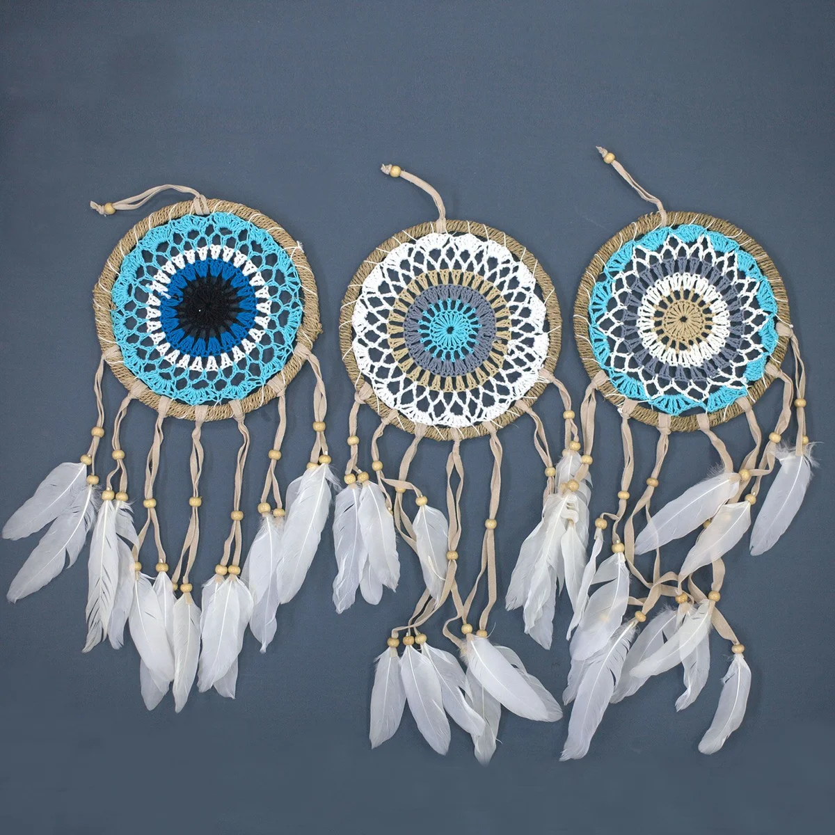 Pastel blue dream catcher with macramé design and 16cm diameter hanging on white background