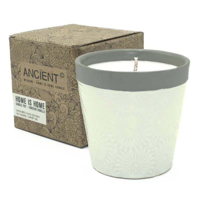 Glass vanilla candle in a simple pot, light wax edges, fragrant aroma.