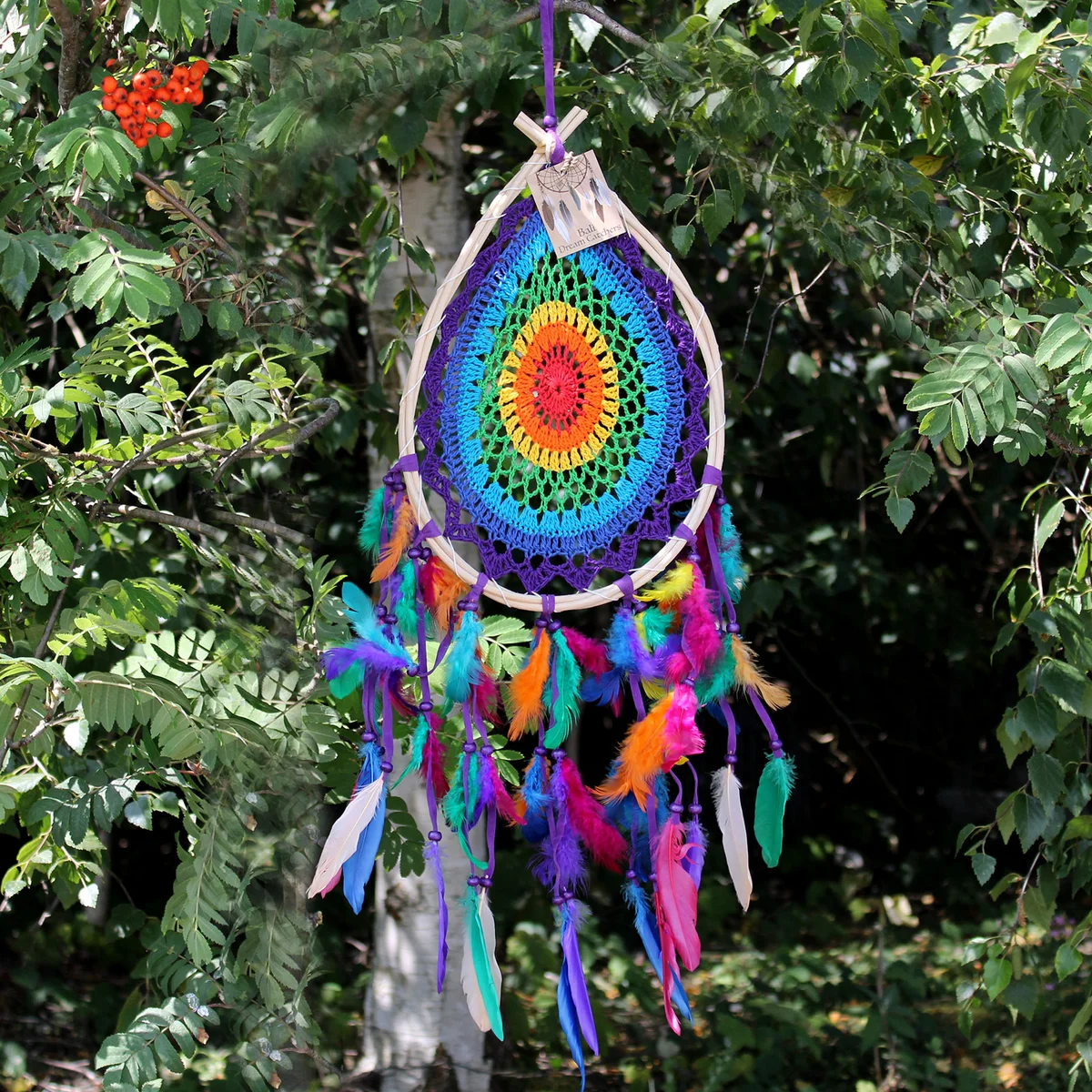 Large multi teardrop dream catcher with intricate webbing and hanging feathers in natural tones