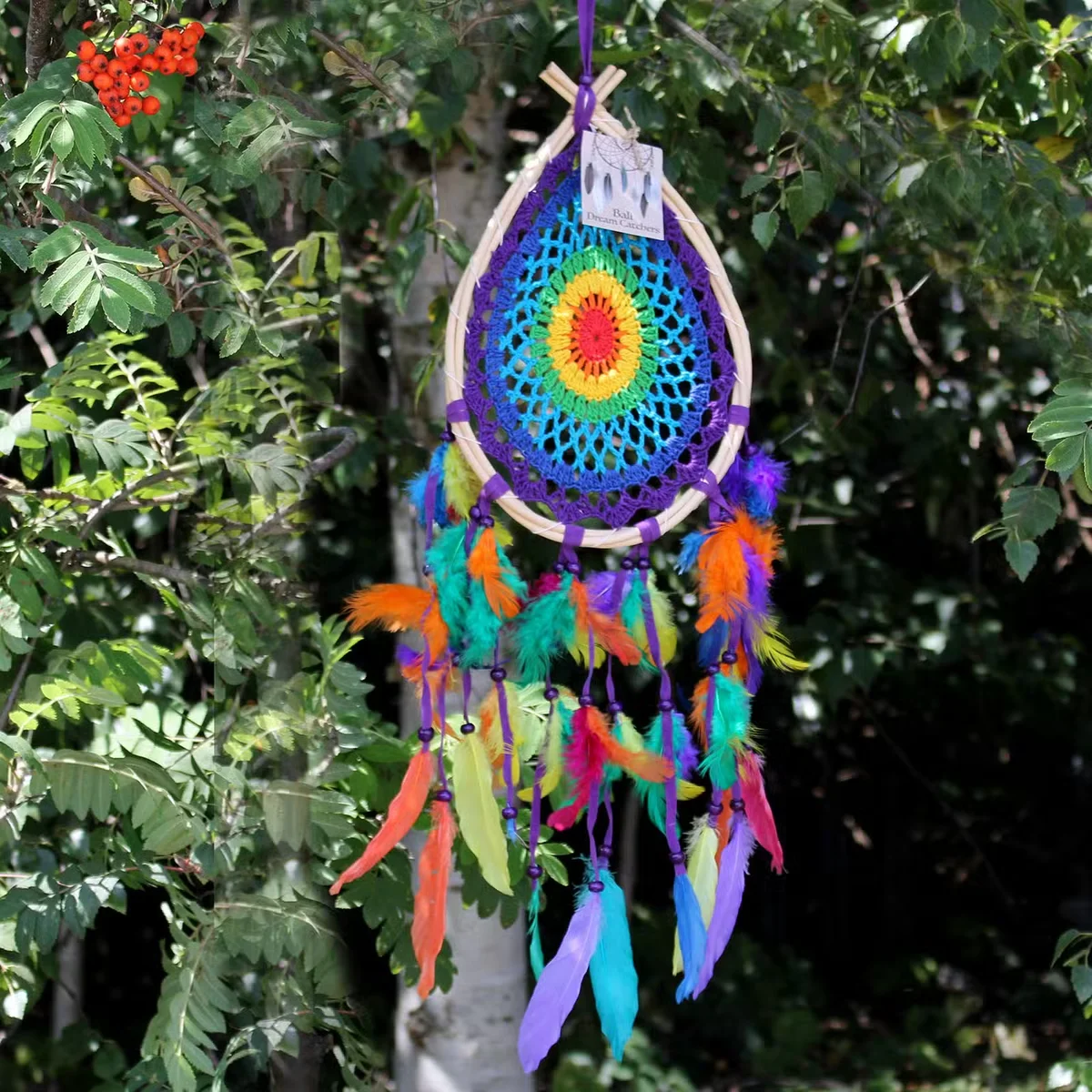 Medium multi teardrop Bali dream catcher boho wall hanging with colorful threads and feathers on white background
