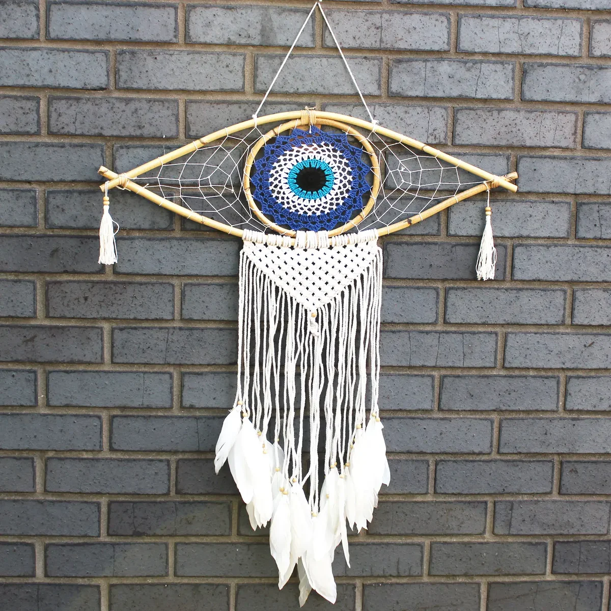 large dream catcher featuring a macrame frame and blue, white, black evil eye charm