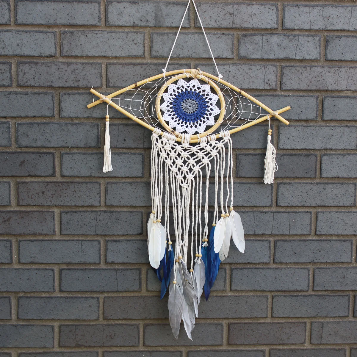 medium macrame dream catcher with an evil eye in blue, grey, and white, a stylish evil eye wall decor