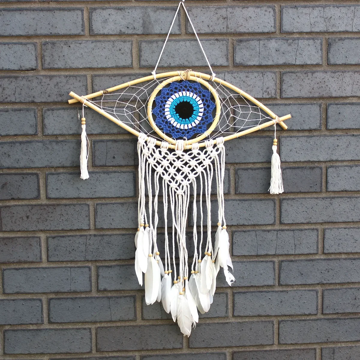 Medium macrame dream catcher with blue, white and black thread, featuring an evil eye charm