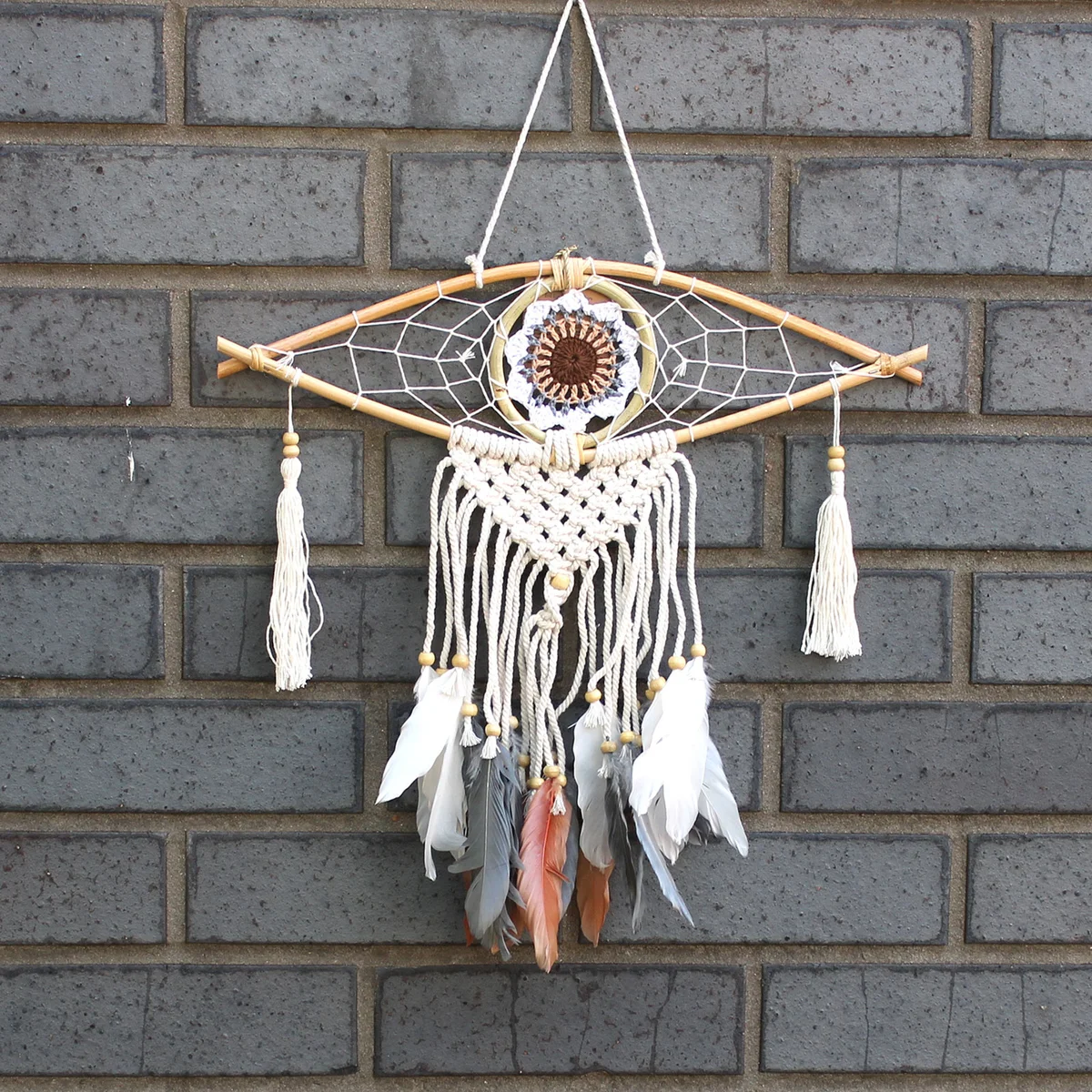 Small macrame wall decor featuring a black macrame evil eye charm.