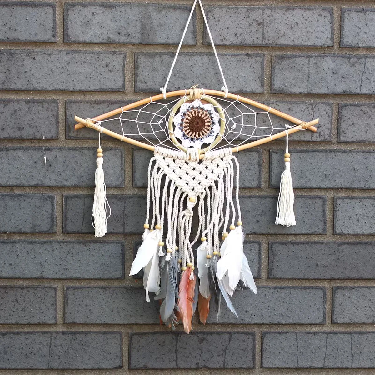 Handmade dream catcher in macramé with a small evil eye design.