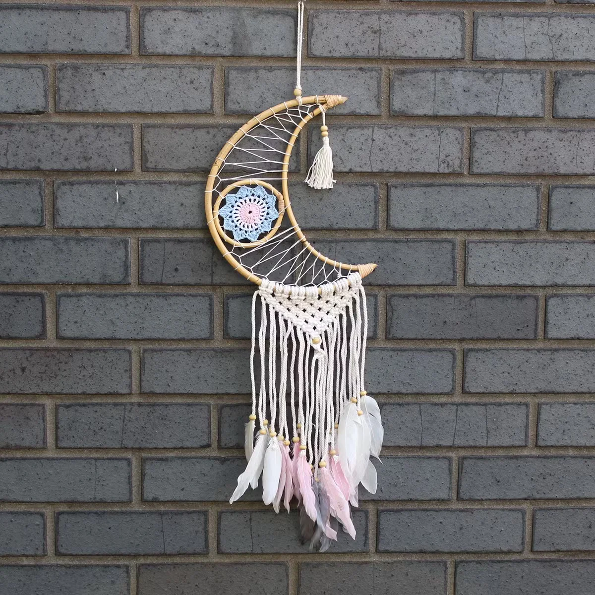 Macrame wall hanging featuring a dream catcher with moon motif.