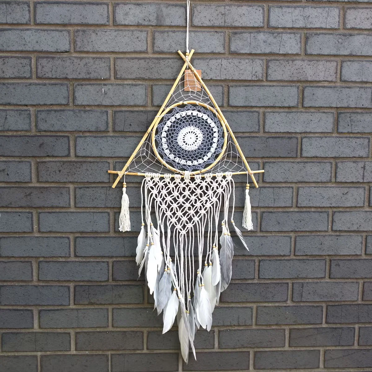 Large white and grey macrame pyramid dream catcher, featuring intricate twisted threads and a netting inside.
