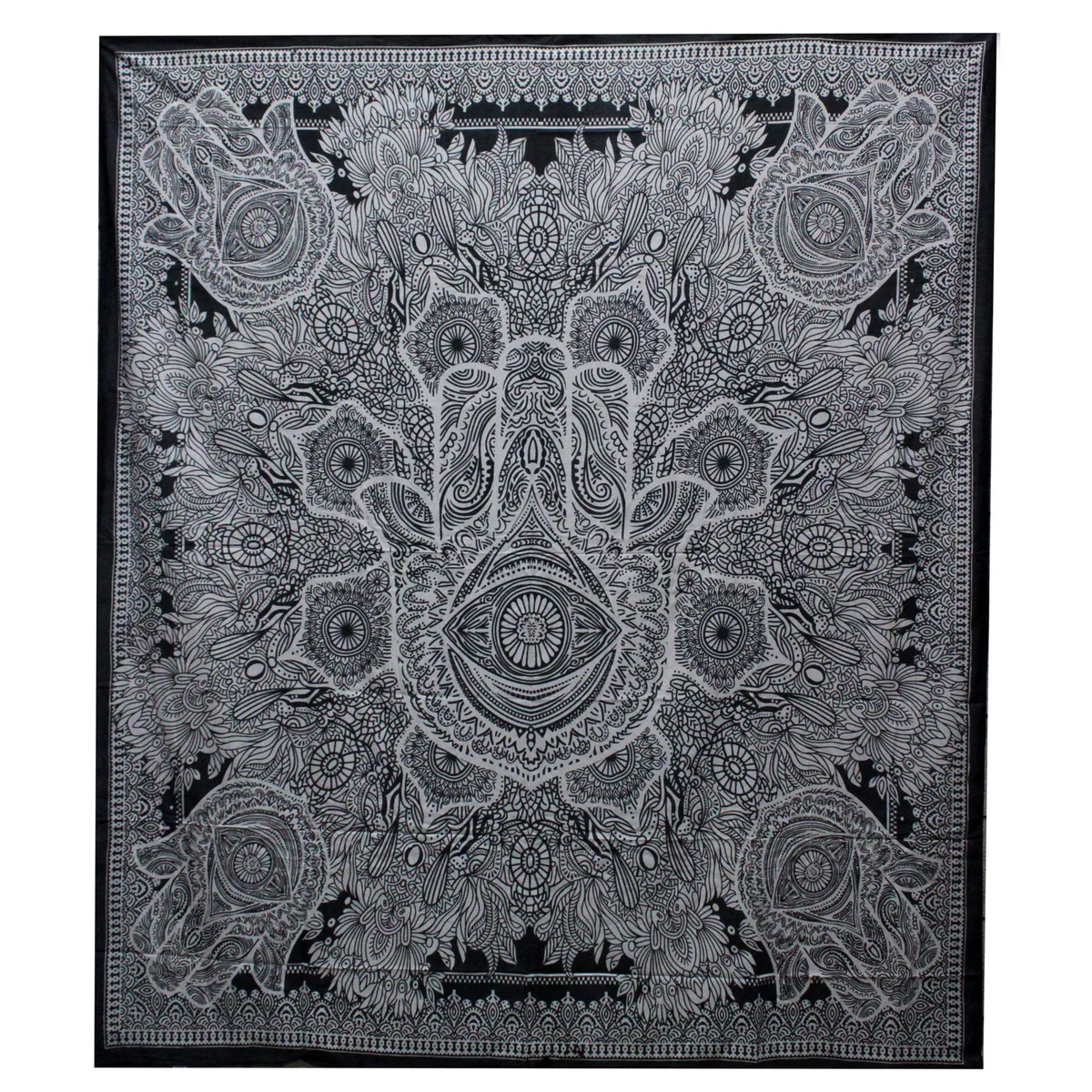 Black and white double cotton bedspread with matching hamsa wall hanging laid out on a bed