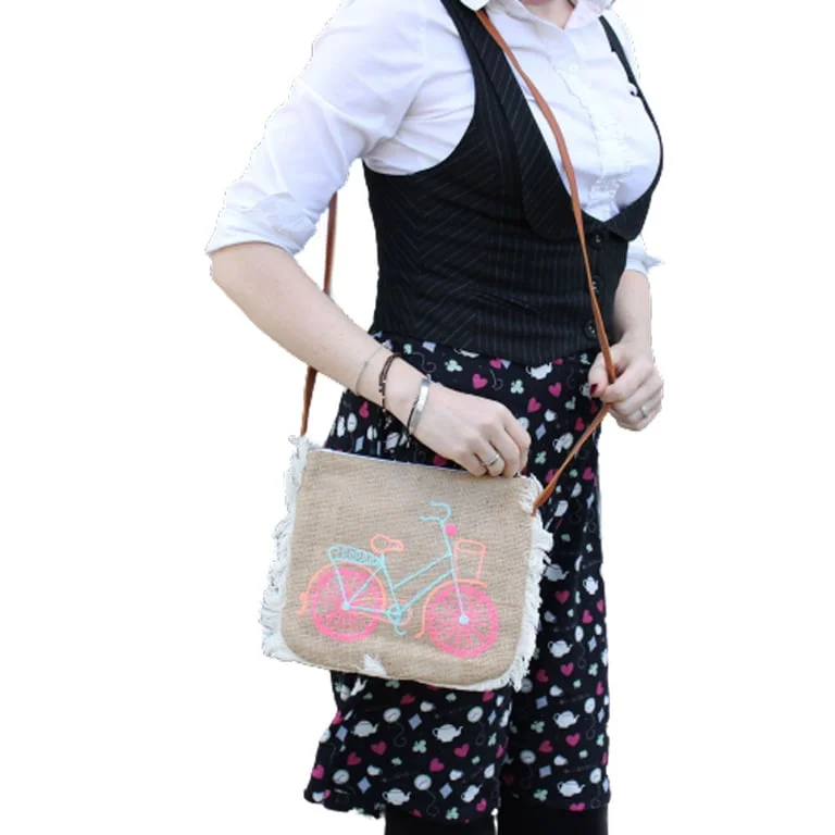 Fringe handbag featuring bicycle embroidered design, open front with fabric straps and fringe detailing.