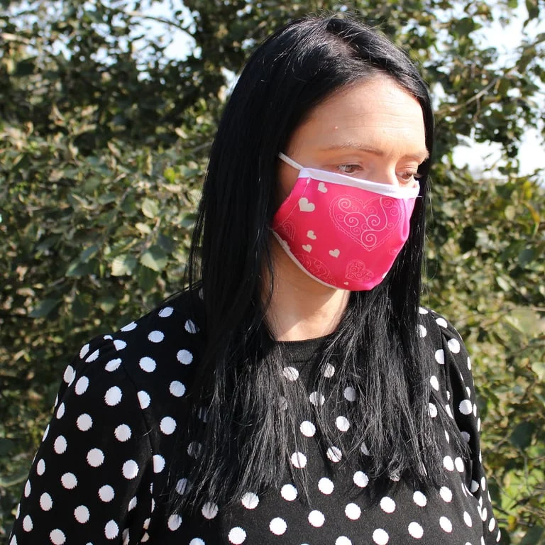 Reusable fashion face mask with pink hearts pattern, suitable for adults