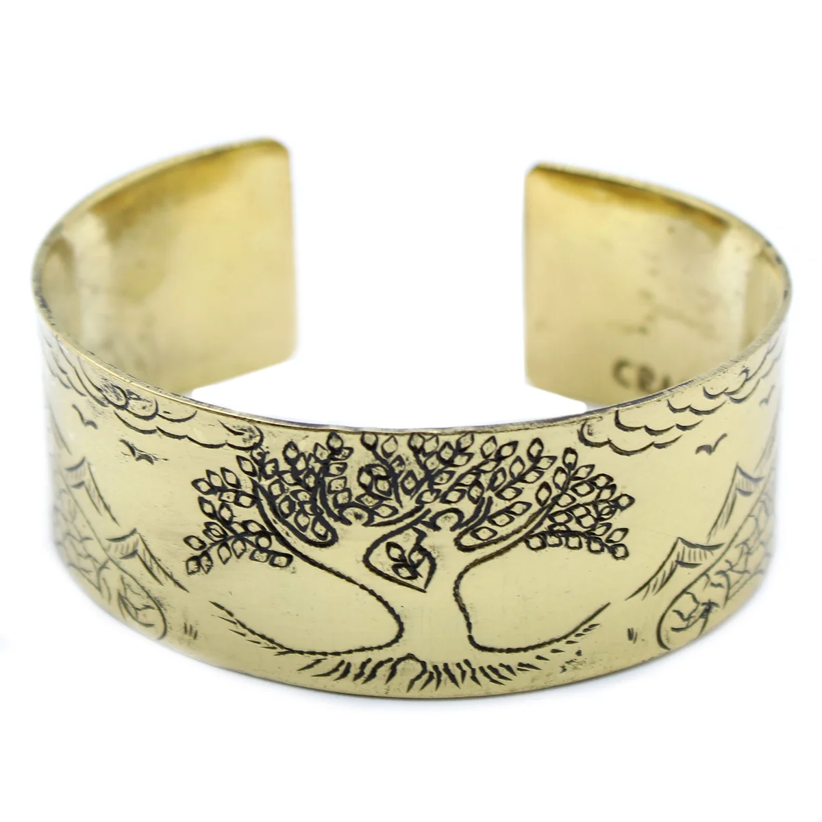 Close-up of brass Tibetan mantra jewellery bracelet featuring Tree of Life design on a wooden background