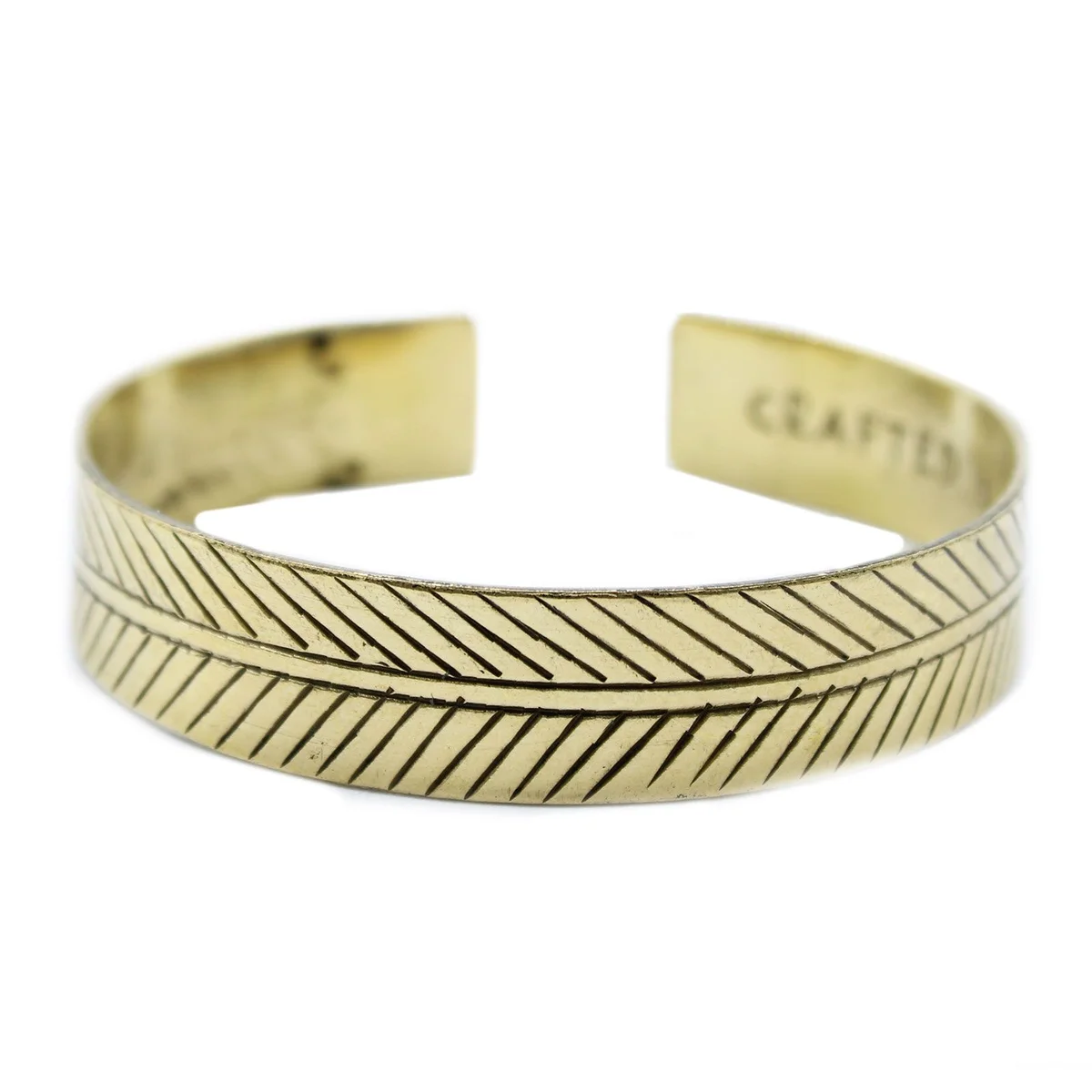 Wide brass Tibetan bracelet featuring a tribal leaf design on a plain white background