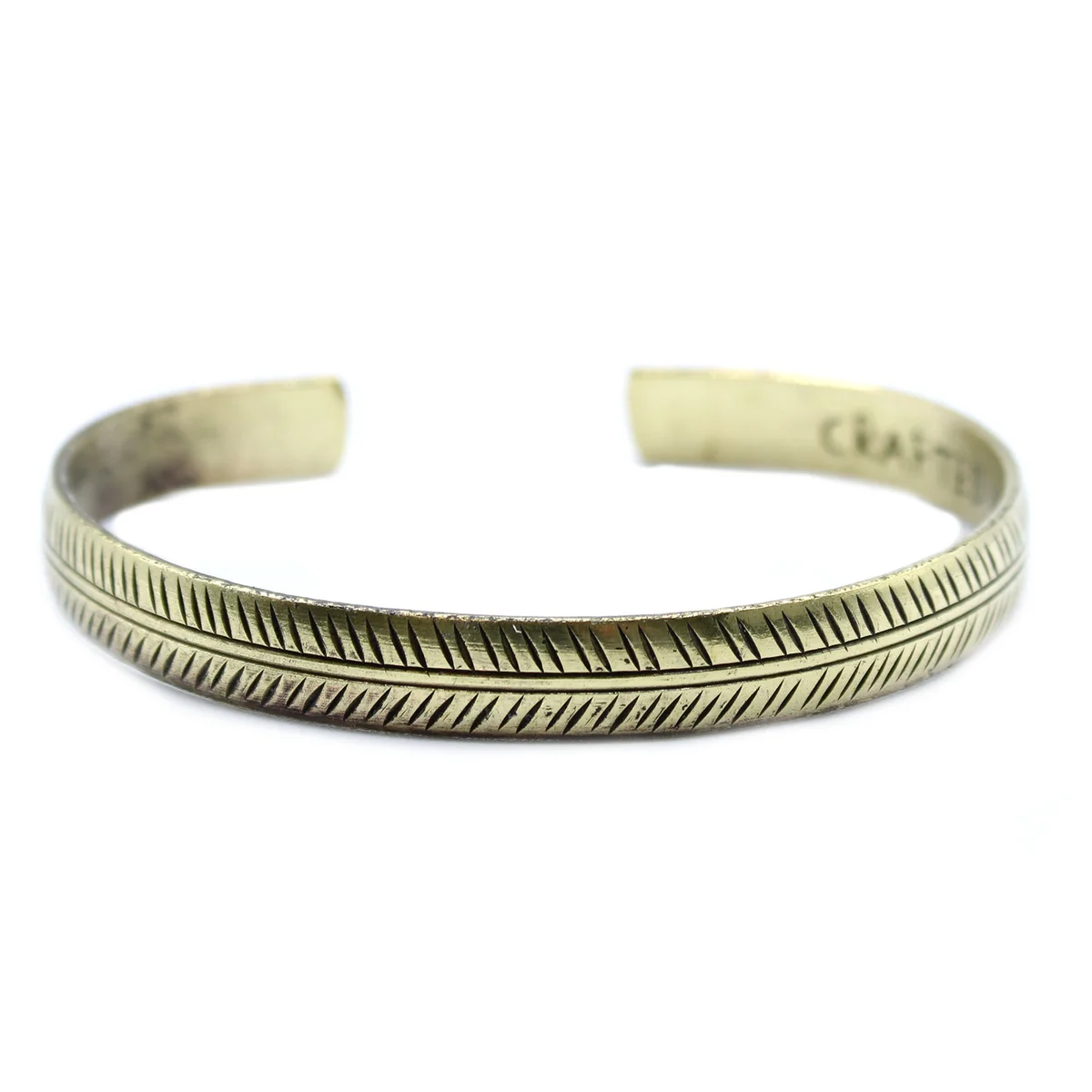 Slim brass Tibetan leaf bracelet with intricate tribal design on a white background