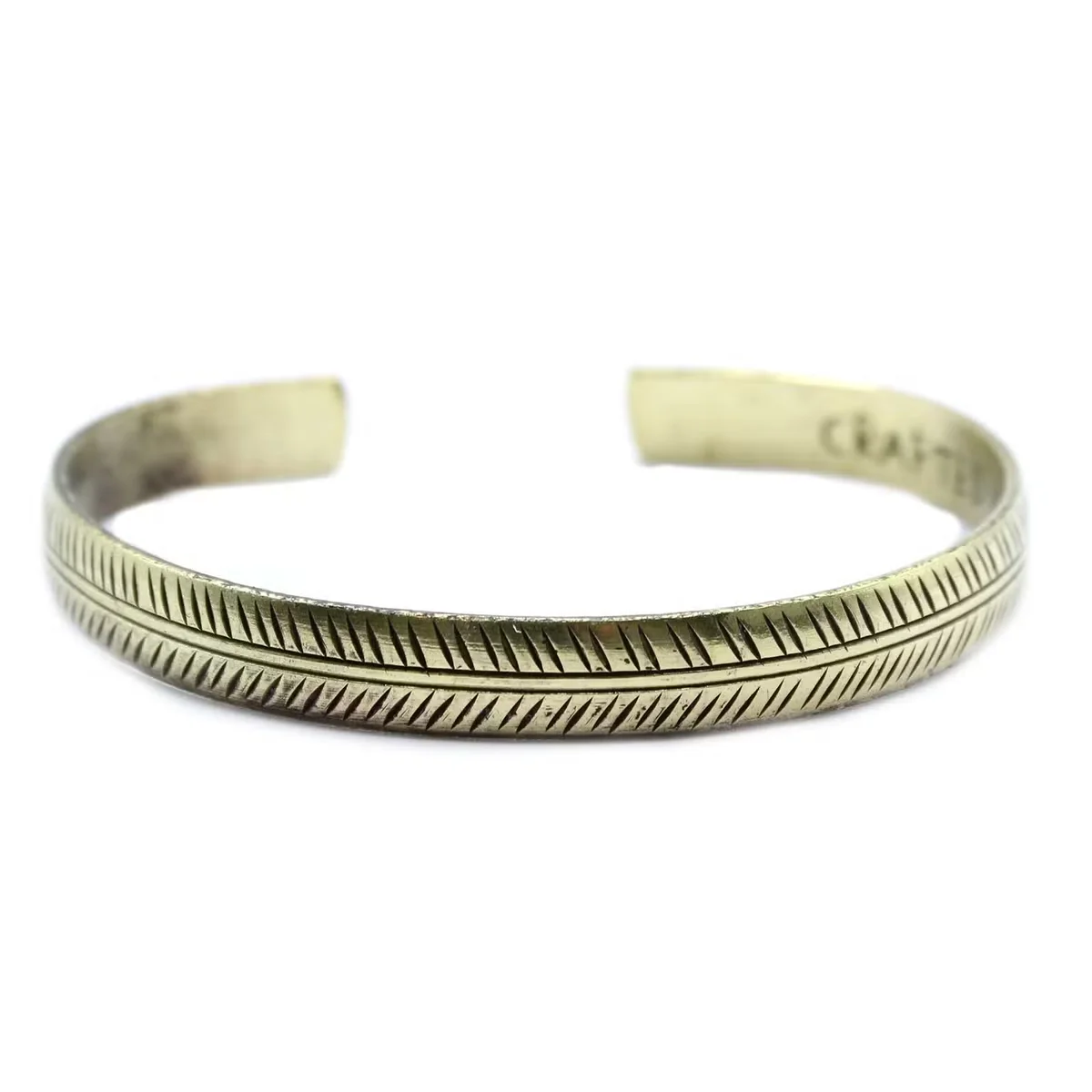 Slim brass leaf bracelet with tribal design, handcrafted Tibetan style, shown on a neutral background
