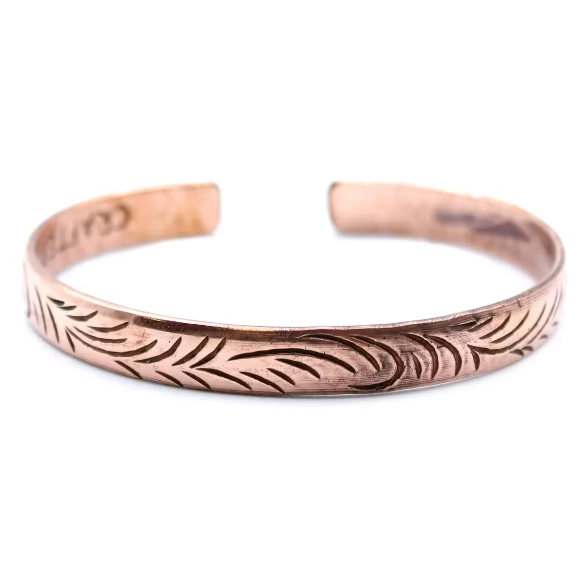 Copper Tibetan slim tribal swirl bracelet with intricate swirling patterns on a copper band against white background