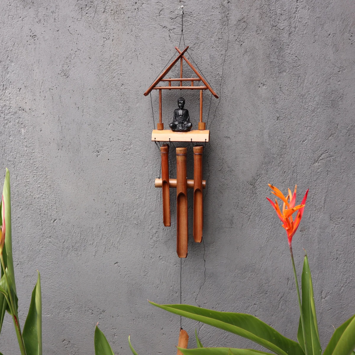 Black Buddha bamboo windchime with six natural finish tubes hanging vertically against a white background