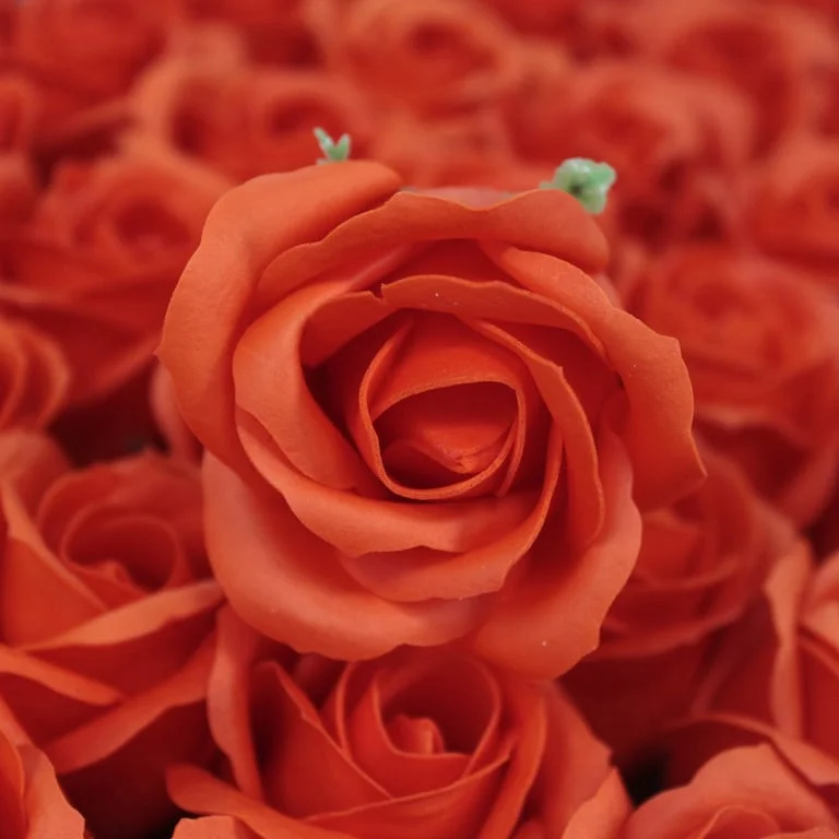 Sunset orange soap shaped like a medium rose, crafted into a flower appearance.