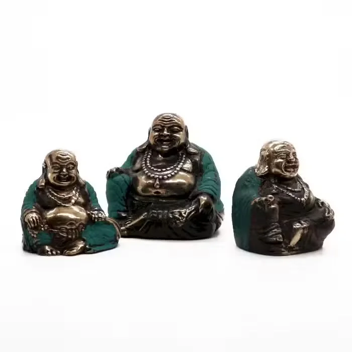 Set of three happy Buddha statues in assorted sizes arranged together on a plain background